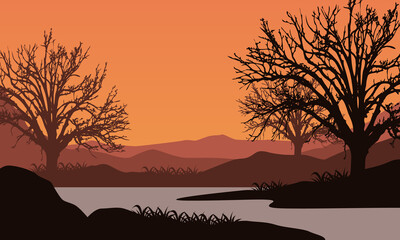 Amazing view of the mountains from the seafront with the silhouettes of big dry trees around