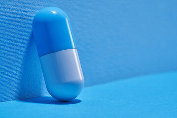 blue white capsule against blue background