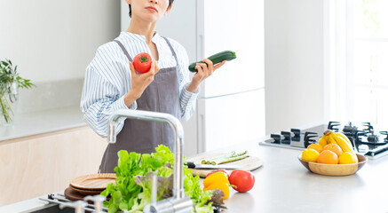キッチン・野菜・悩む女性