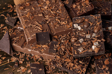 Grated chocolate and pieces of tasty chocolate on table