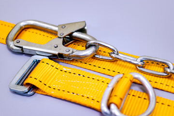 Safety belt for work at height with carabiner. Professional safety equipment for mountaineering and construction. Safety precautions. Close-up.