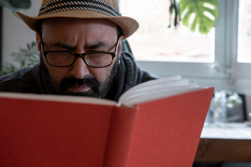 fifty year old spanish man with hat with a book