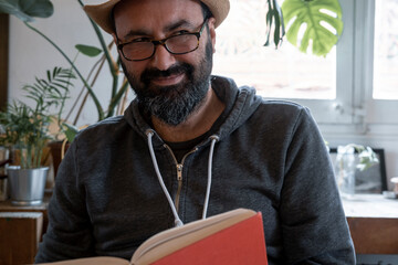 fifty year old spanish man with hat with a book