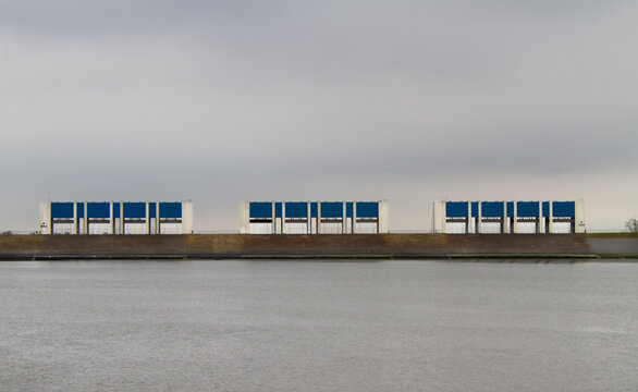 Three enormous sluices in the dikes of the Dutch Waddesea, part of the Deltplan, under a dark sky