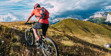 Rowerem górskim kolarz przemieszcza się ścieżkami rowerowymi, Dolomity na rowerze elektrycznym - obrazy, fototapety, plakaty