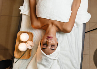 cropped view of healer putting hands near head of woman with closed eyes lying on massage table