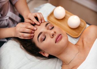 Face massage. Close-up of young woman getting spa massage treatment at beauty spa salon.Spa skin and body care. Facial beauty treatment.Cosmetology.