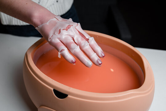Process paraffin treatment of female hands in beauty salon