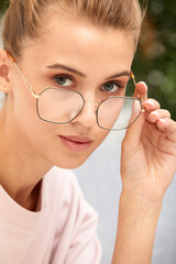 Close-up shot of smiling attractive happy and successful european blond female in sweater watch and glasses grinning expressing confidence, looking accomlished and daring at camera with sassy smile.