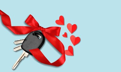 Car key with a red bow and a heart. Giving present or gift for valentine day or christmas.