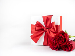  Box with red bow and red roses on white background for decoration. Promotional template. Holiday concept. Creative modern design.