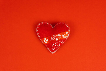 Top view Valentine's Day concept with copy space. Red textile heart on red papper background