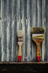 two old paint brushes on a zinc background