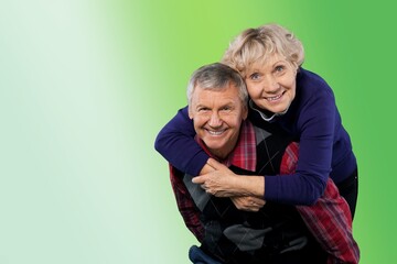 Senior man carrying his wife on his shoulders laughing. Attractive crazy old senior couple