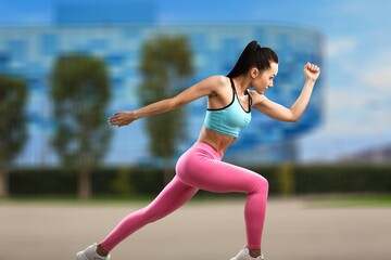 Fototapeta premium Happy fitness woman outdoors. Athletic girl wearing sportswear posing