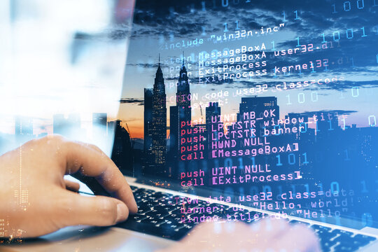 Close up of man hand using laptop keyboard with abstract html code on creative city background. Coding and programming concept. Double exposure.