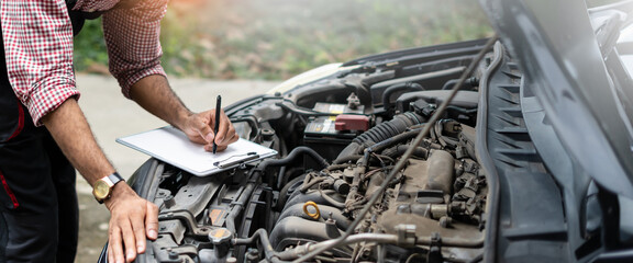 Car service and maintenance,Repair service concept.Automobile mechanic repairman hands repairing and checking a car engine automotive workshop.