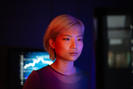Asian female working on a computer bitcoin mining in a futuristic style