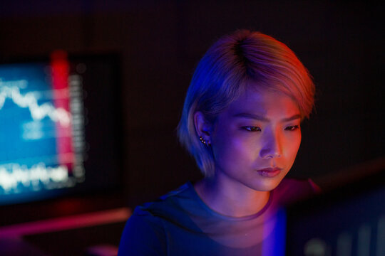 Asian female working on a computer trading in a futuristic style