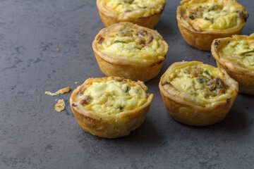 Mini ham, cheese and herb quiches freshly baked on a grey board ready to eat - close up  photo