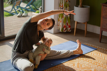 New Mum practicing yoga with Newborn in arms at home