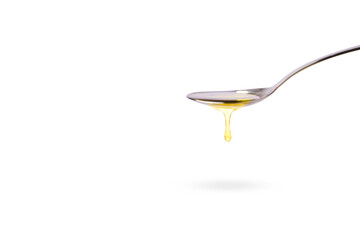 Oil in spoon dripping isolated on white background
