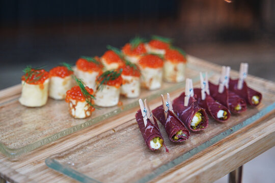 small appetizers with red caviar and meat rolls