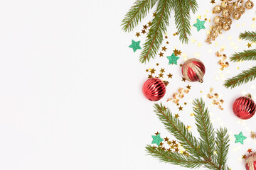 Frame made of Christmas decorations and fir tree branches on a white background.