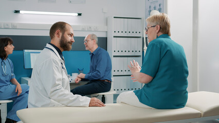 Obraz premium Male doctor consulting senior woman in medical cabinet, having conversation about disease and health care treatment. General practitioner doing checkup consultation with elder patient.