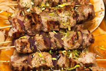 Grilled pork kebabs on wooden skewers in pita close up.