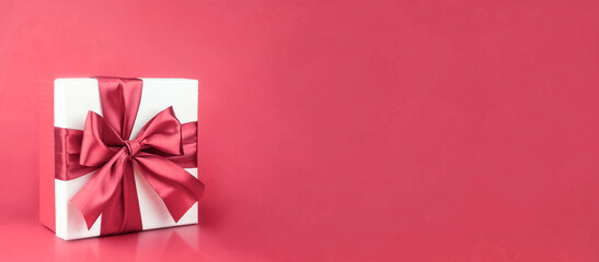  Gift box with bow on pink background for decoration. Promotional template. Holiday concept. Creative modern design.