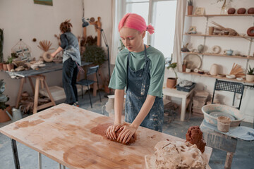Skillful potter working with clay in workroom