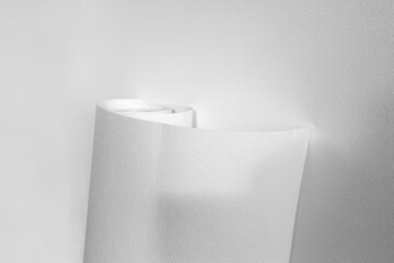 Rolled sheet of white textured wallpaper, on white background. Wallpaper Rolls Mockup