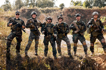group of equipped and armed special forces soldiers standing in field. Concept of military...