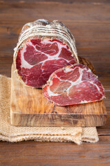 Capocollo of martina franca on wooden table typical from apulia south italy. Italian salami