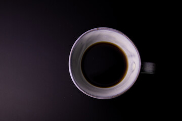 Black Coffee in a white ceramic Cup on Black Background