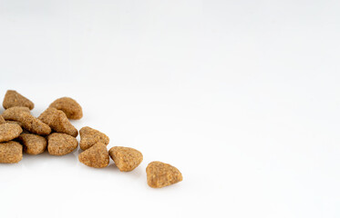 close up of dog food pellets on white background	