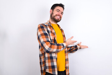 young caucasian man wearing plaid shirt over white background Inviting to enter smiling natural with open hands. Welcome sign.