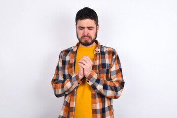 Sad young caucasian man wearing plaid shirt over white background feeling upset while spending time...