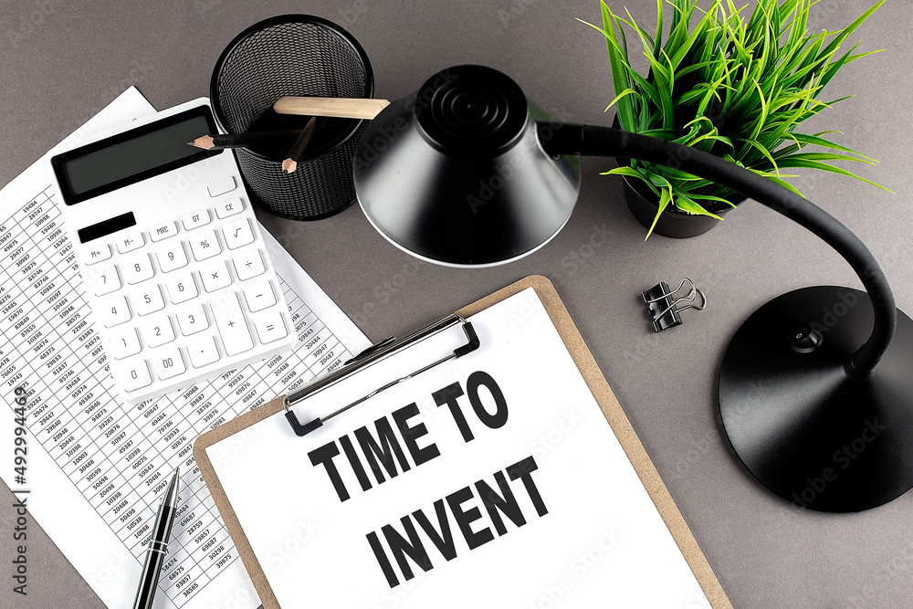 Poster clipboard ,chart and calculator, lamp and workspace accessories on a grey table. top view , text tim