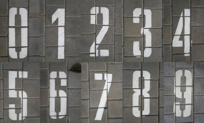 Numbers from zero to nine on pavement in grey color.