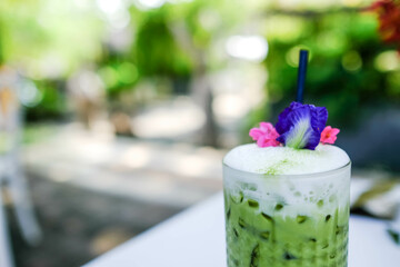 Iced Matcha latte tea with a blur background.