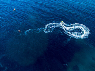 Aerial drone view of motor boat at blue sea. Motorboat in the tropical waters at summer. Tourists on a motor boat trip. Tourists ride high-speed boat on the water. 