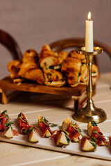 prosciutto with gorgonzola and pear Summer snacks. Pear appetizer with jamon, arugula and brie cheese on black table with copy space background.