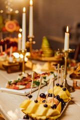 Meal. Festive buffet table for guests. Assortment of cold cuts,canapes on wooden skewers, festive snacks with fruits and salads. Reception at the party