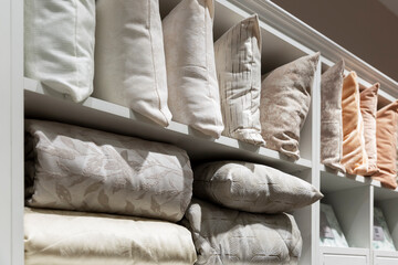 Selection of pillows and blankets in the store. Stylish and cozy home decor. Close-up.