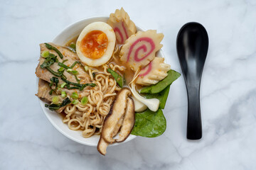 Ramen Soup bowl With black spoon over marble table
