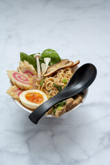 Ramen Soup bowl With black spoon over marble table