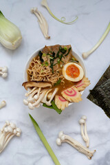 A bowl of ramen soup with all the ingredients over a marble table