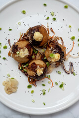 A plate of takoyaki over a marble table